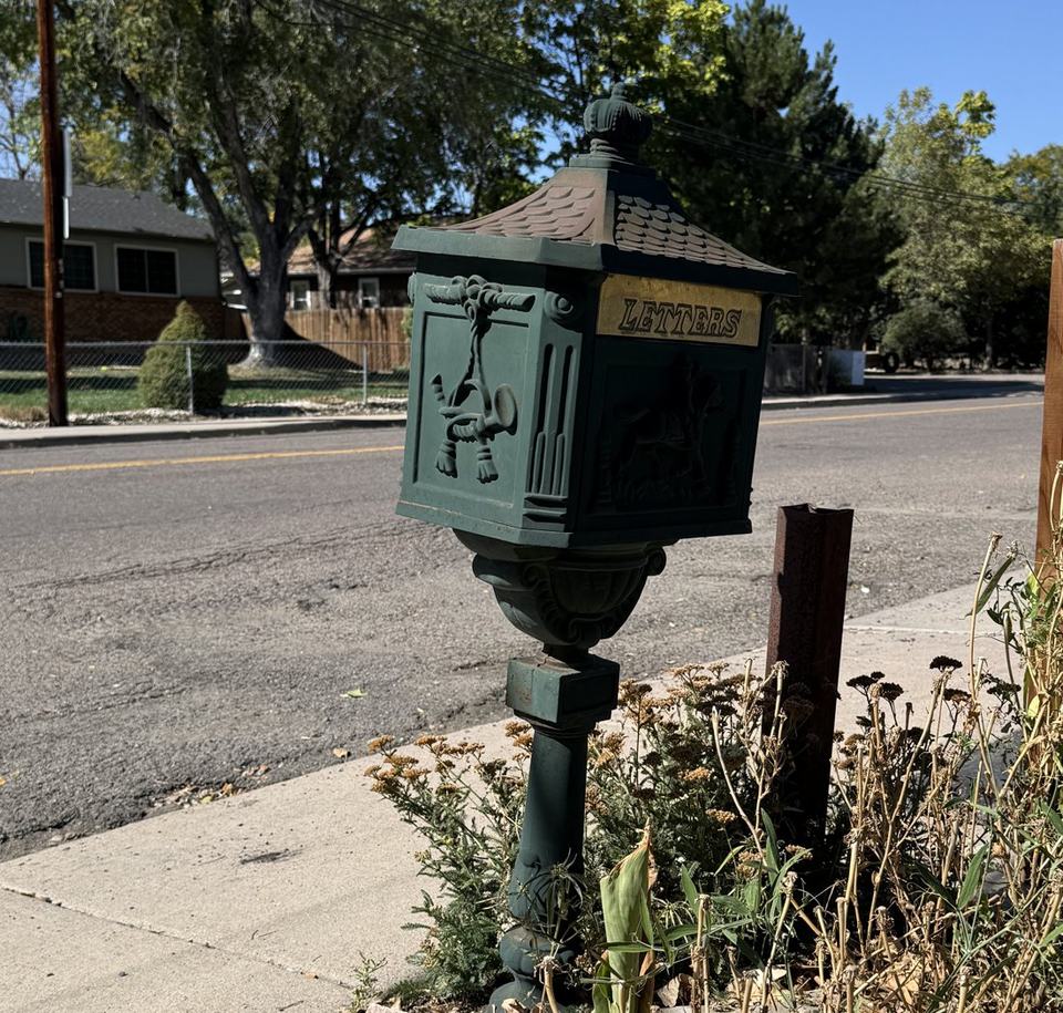 Antique green mailbox at the curb
