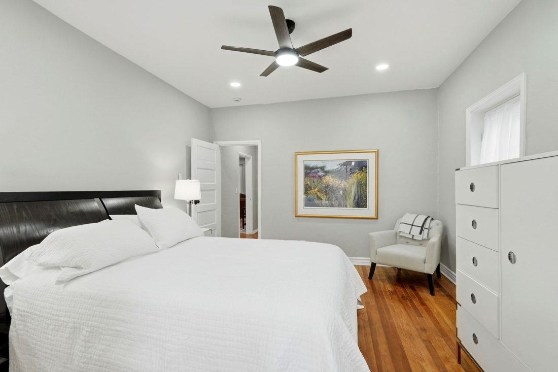 Shizukesa: king bed with white linens and a ceiling fan